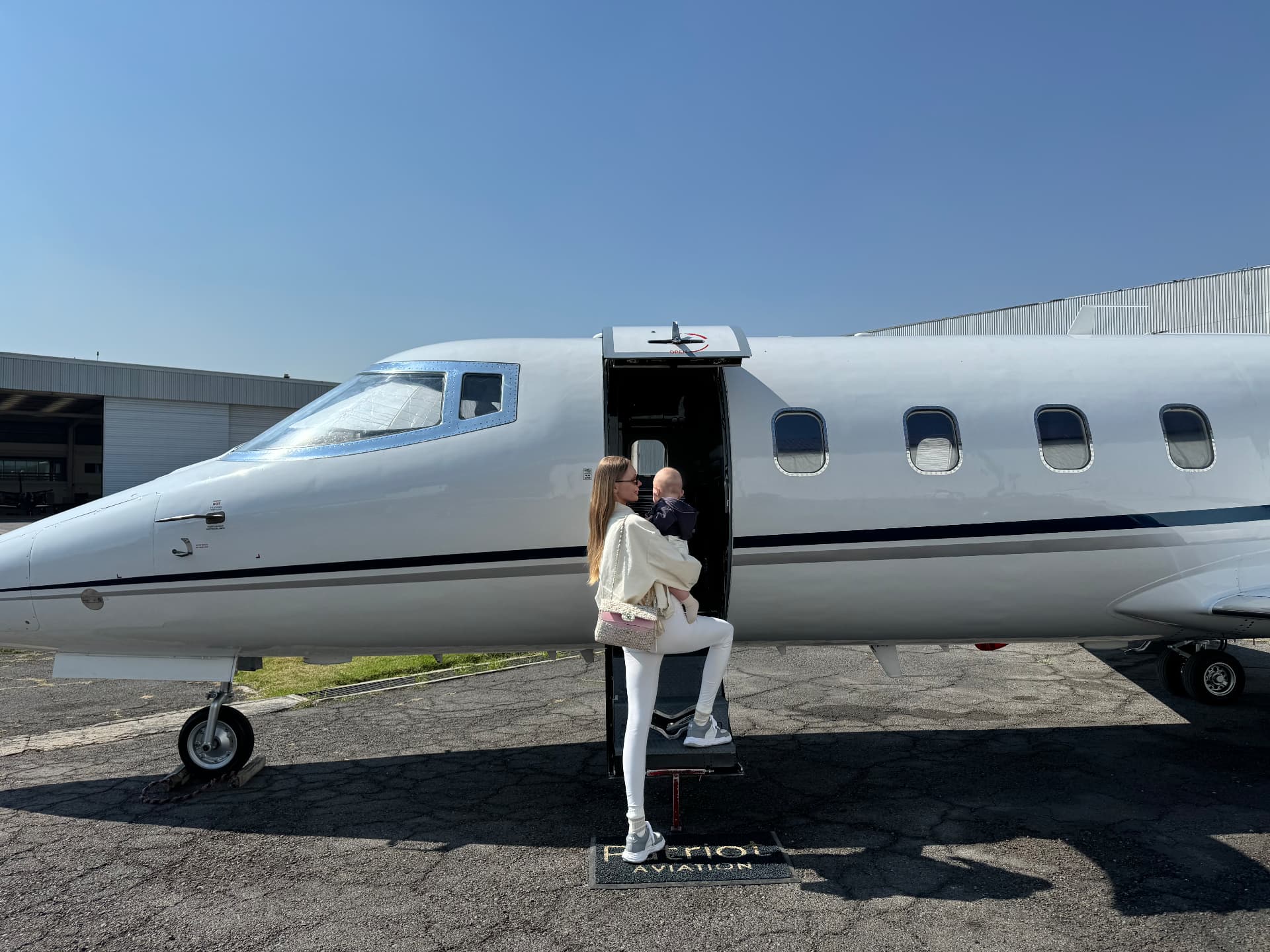 Natalie boarding a private jet with her child
